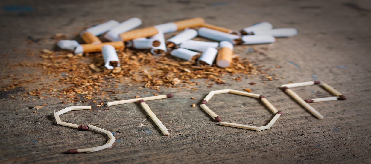 Zigaretten liegen auf dem Boden und mit Streichhölzern ist ein Stop geschrieben.