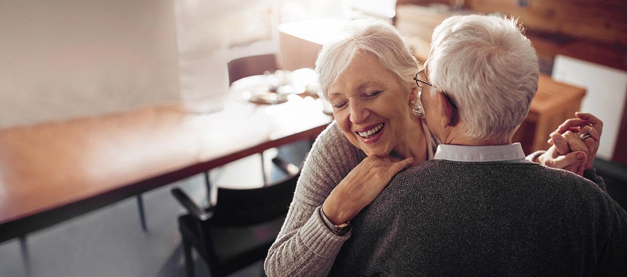Glückliches Seniorenpaar dank passender Pflegeversicherung